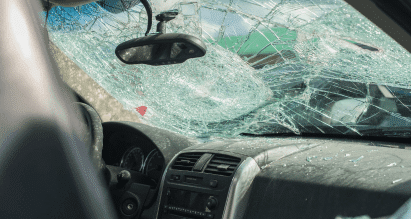 Binnenkant van auto met gebarsten voorruit na schade — voorbeeld van autoschade die invloed kan hebben op je verzekeringspremie.